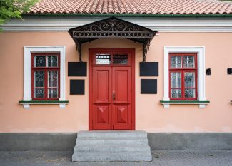 Vintage architecture featuring a classical facade of a building with a striking red door