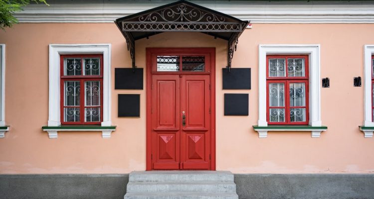 Vintage architecture featuring a classical facade of a building with a striking red door